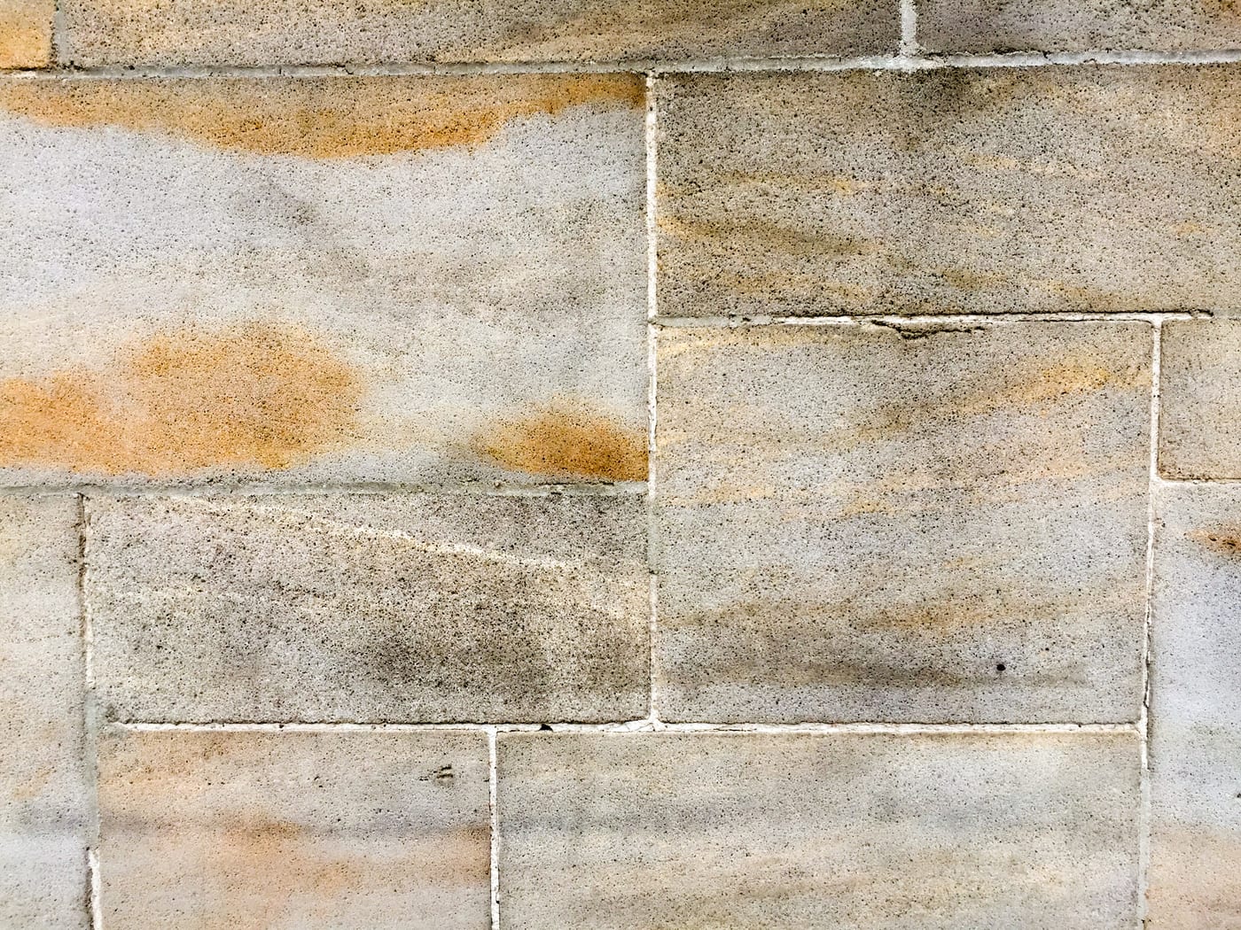 Détail d'un mur de pierre appareillée, joints fins et lumière rasante.